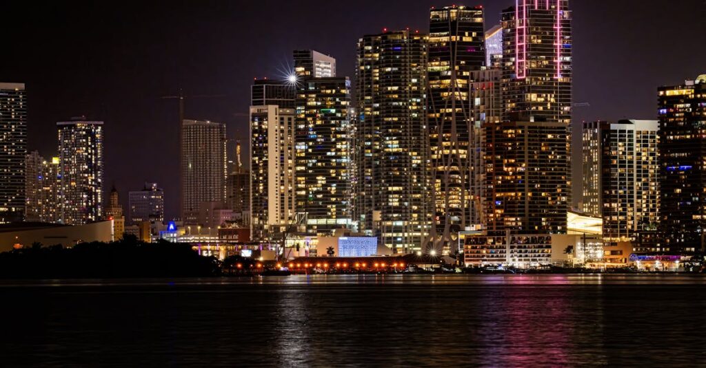 Vibrant Miami skyline illuminated at night, reflecting in the tranquil water.